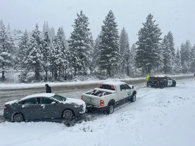 Ridgeline Towing recovering a sedan stuck in a snowbank during an I-80 snowstorm